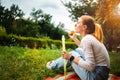 Young woman is blowing a soap bubbles in summer park. Royalty Free Stock Photo