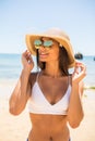 Young woman in blue bikini wearing white straw hat enjoying summer vacation at beach. Portrait of beautiful latin woman relaxing a Royalty Free Stock Photo