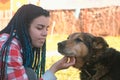 Young woman with blue braids hairs pet the dog outside. Royalty Free Stock Photo