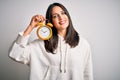 Young woman with blue eyes holding alarm clock standing over isolated white background with a happy face standing and smiling with Royalty Free Stock Photo