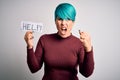 Young woman with blue fashion hair asking for help showing message on paper annoyed and frustrated shouting with anger, crazy and Royalty Free Stock Photo