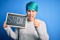 Young woman with blue fashion hair holding blackboard with strong message annoyed and frustrated shouting with anger, crazy and