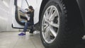 Young woman in blue gloves is cleaning interior of the car for luxury SUV Royalty Free Stock Photo