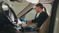 Young woman in blue gloves is cleaning interior of the car for luxury SUV Royalty Free Stock Photo