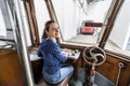 Young woman in a blue jacket and jeans is driving old tram. The girl sits in the driver seat and looks over her shoulder into Royalty Free Stock Photo