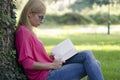 Young woman in blue jeans reading book. Royalty Free Stock Photo