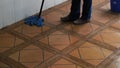 Young woman in blue jeans washes the floor in the lobby of an apartment building