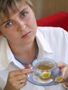 Young woman in blue necklace drinking tea Royalty Free Stock Photo