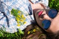 Young woman in blue plaid shirt with red lips, sunglasses and little yellow flowers in blonde hair Royalty Free Stock Photo