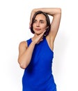Young woman in blue sleeveless dress poses in the studio on a white background. Hands near head Royalty Free Stock Photo