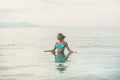 Young woman in blue swimsuit standing in sea in Alanya