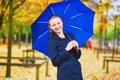 Young woman with blue umbrella in the Luxembourg garden of Paris on a fall or spring rainy day Royalty Free Stock Photo