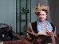 Young woman in blue vintage dress late 19th century reading the book in retro room Royalty Free Stock Photo