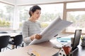 Young woman with blueprint working at home office Royalty Free Stock Photo