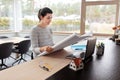 Young woman with blueprint working at home office Royalty Free Stock Photo