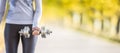 Young woman body in fitness wear exercising with dumbbell and headphones Royalty Free Stock Photo