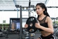 young woman bodybuilder execute exercise in fitness center. female athlete lift heavy weight barbell plate in gym. sporty girl