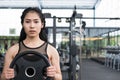 young woman bodybuilder execute exercise in fitness center. female athlete lift heavy weight barbell plate in gym. sporty girl