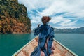 Young woman in boho style dress on boat at the lake Royalty Free Stock Photo