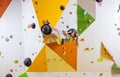 Young woman bouldering in indoor climbing gym