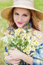 Young woman with a bouquet of field daisies