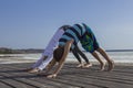 Young woman and boy child practicing yoga, standing in downward facing dog exercise