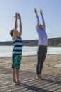 Young woman and boy stretching hands to the sky