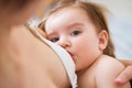 Young woman breastfeeding her baby on blurred background, closeup. Mom nursing and feeding baby. Close-up portrait of Royalty Free Stock Photo