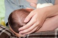 Young woman breastfeeding her baby at home. Milk from mother's breast is a natural medicine to baby. Mother day Royalty Free Stock Photo