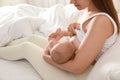 Young woman breastfeeding baby on bed at home, closeup Royalty Free Stock Photo