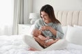 Young woman breastfeeding her little baby on bed at home Royalty Free Stock Photo