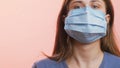 Young woman breathing heavily andshowing at the protective medical mask on studio background, concept healthcare, personal respons