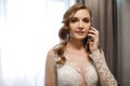 Young woman bride in a wedding dress talking on a cell phone while accepting congratulations Royalty Free Stock Photo
