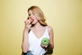 Young woman with bright lips makeup eating donuts. Royalty Free Stock Photo