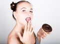 Young woman in bright makeup eating a tasty donut with icing. Funny joyful woman with sweets, dessert. dieting concept Royalty Free Stock Photo