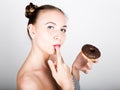 Young woman in bright makeup eating a tasty donut with icing. Funny joyful woman with sweets, dessert. dieting concept Royalty Free Stock Photo