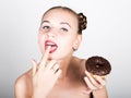 Young woman in bright makeup eating a tasty donut with icing. Funny joyful woman with sweets, dessert. dieting concept Royalty Free Stock Photo