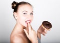 Young woman in bright makeup eating a tasty donut with icing. Funny joyful woman with sweets, dessert. dieting concept Royalty Free Stock Photo