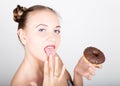 Young woman in bright makeup eating a tasty donut with icing. Funny joyful woman with sweets, dessert. dieting concept Royalty Free Stock Photo