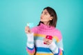 Young woman in a bright multicolored sweater on a blue background Royalty Free Stock Photo