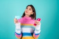 Young woman in a bright multicolored sweater on a blue background Royalty Free Stock Photo