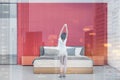 Young woman in bright red and white bedroom Royalty Free Stock Photo