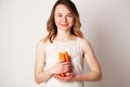 Young woman in a bright room holding a carrot Royalty Free Stock Photo