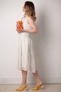 Young woman in a bright room holding a carrot Royalty Free Stock Photo