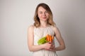 Young woman in a bright room holding a carrot Royalty Free Stock Photo