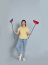 Young woman with broom and dustpan on grey background Royalty Free Stock Photo