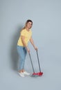 Young woman with broom and dustpan on background Royalty Free Stock Photo