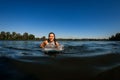 Young woman with brown hair floats on the river on wakesurf board Royalty Free Stock Photo