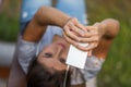 Selfie-taking woman, white phone, wired earphones, park Royalty Free Stock Photo