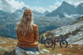 Young woman looking at the mountain view with her bicycle on the side Royalty Free Stock Photo